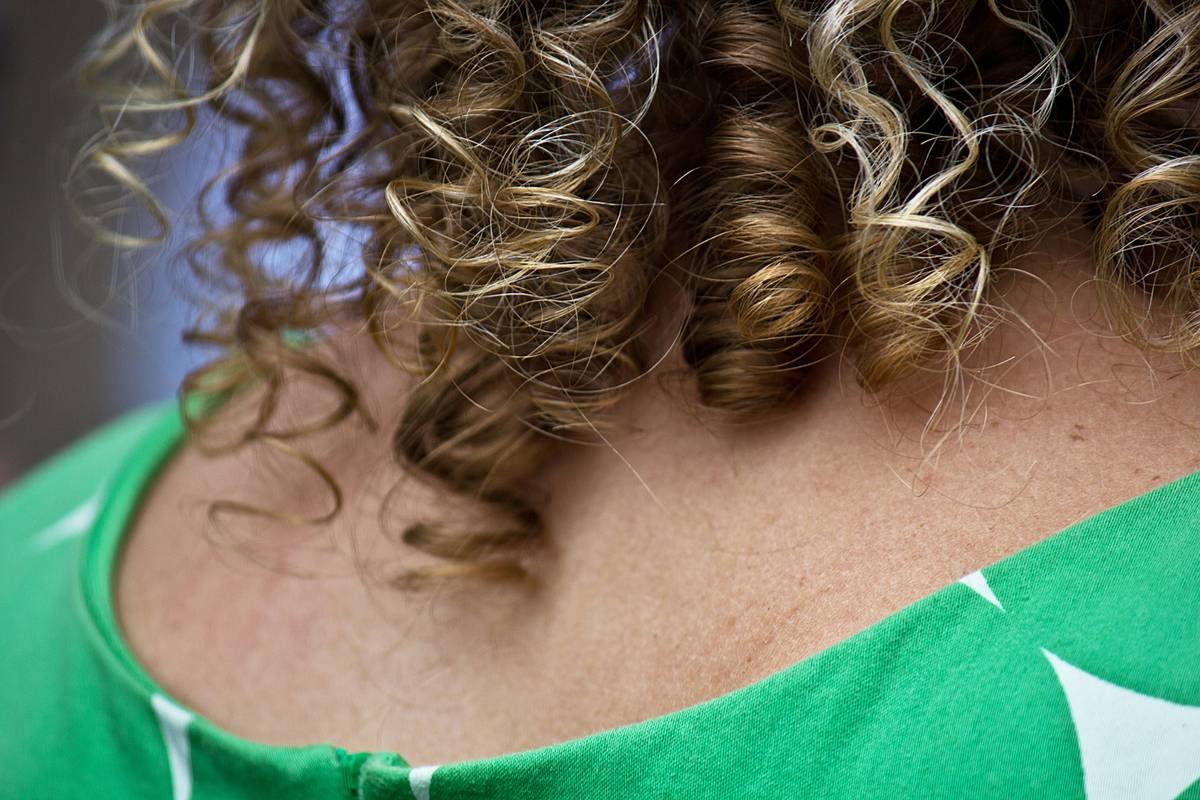 A model showcasing soft, bouncy curls achieved with hair rollers.